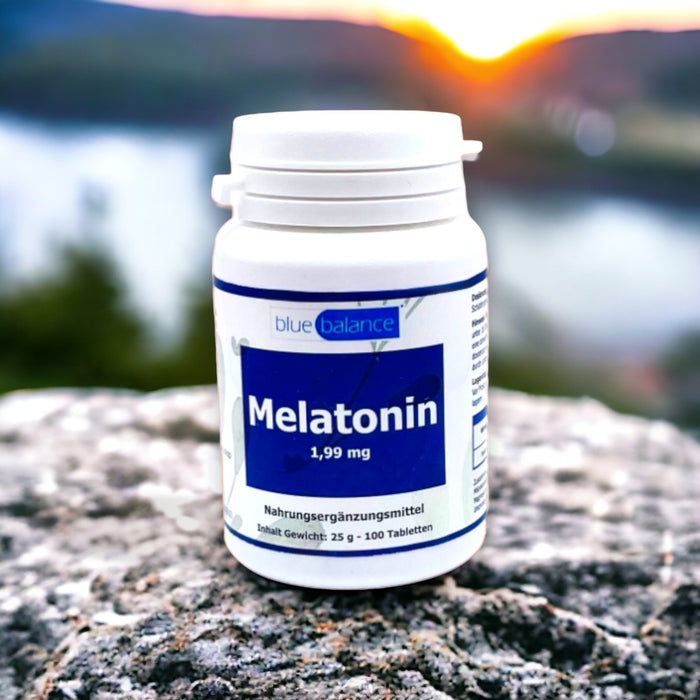 Melatonin-Tablettendose von Blue Balance ETH Meditec drapiert auf einem robusten Felsen, im Hintergrund ein malerischer Sonnenuntergang, der die Idee von natürlicher Schlafunterstützung visualisiert.